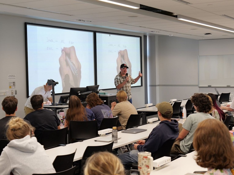 Students listen to a presenter in a classroom