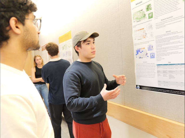 A student telling another person about his research poster